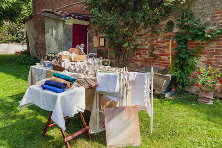 Flea market stall showcasing vintage linens, homeware, and decor during an outdoor sale