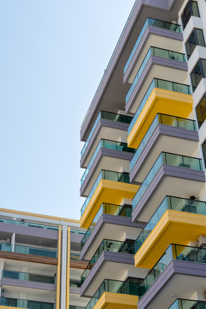 Bottom view of a residential complex with colorful balconies. Sunny day.の写真素材