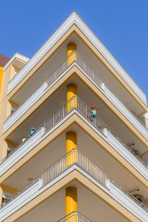 A row of identical large yellow triangular balconies.の写真素材