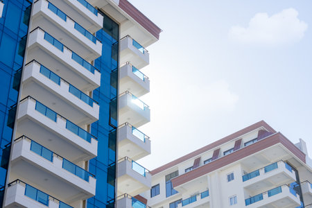Detail of a modern luxury complex. The sun peeking out from behind one of the buildings. glass surface.の写真素材