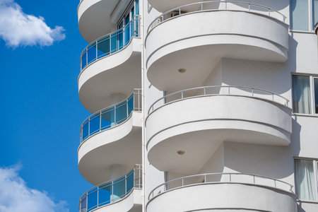 Part of a white high-rise building with large round balconies.の写真素材