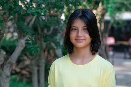 Portrait of a smiling beautiful girl in a city park.の写真素材