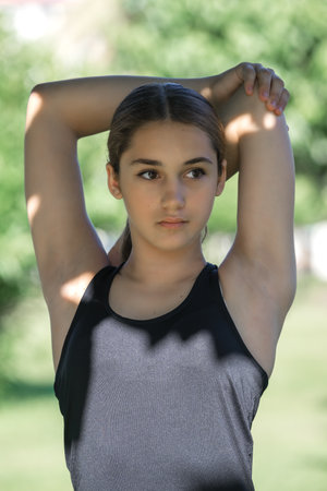Teenage girl doing muscle stretching exercise in a city park. close-up.の写真素材