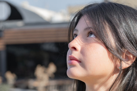 Portrait of a young girl looking up at the sky. side view.の写真素材
