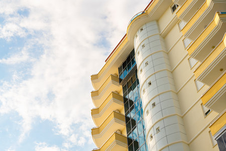 Exterior of a modern apartment building against a blue sky with clouds. residential properties.の写真素材