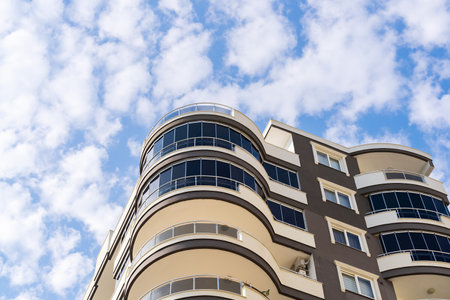 Exterior of a modern apartment building against a blue sky with clouds. residential properties.の写真素材