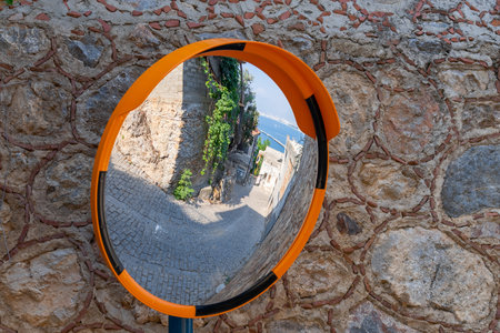 The mirror outside is convex, installed on a dangerous section of the street of the old town.の写真素材