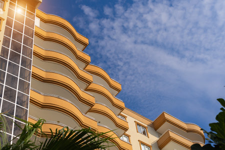 Exterior of a modern apartment building against a blue sky with clouds. residential properties.の写真素材