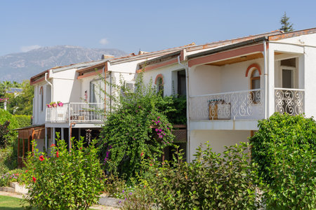 Low white houses against a blue sky with a mountain. Sunny day.の写真素材