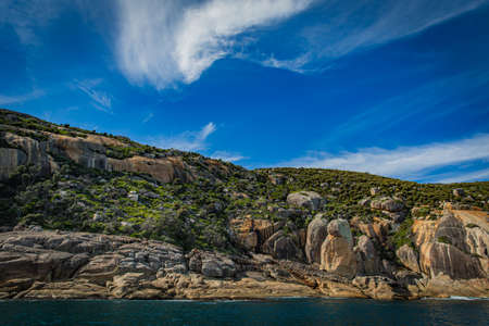 Stone rock mountain forest seascape in Cruising tour view in the Bass Strait at Wilson Promontory Victoria Australia, blue sky and blue seaの写真素材