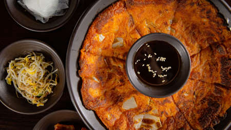 Top view of Korean Grilled BBQ combo sets with kimchi pancake with pancake sauce on the dark plate and black table vibe backgroundの写真素材