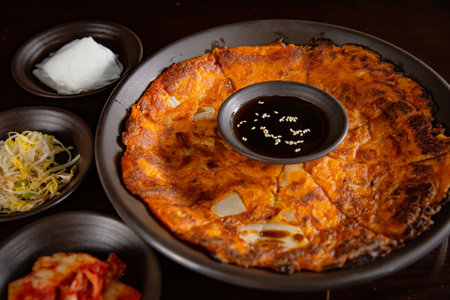 Korean Grilled BBQ combo sets with kimchi pancake with pancake sauce on the dark plate and black table vibe backgroundの写真素材