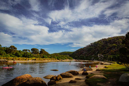 Tidal River at Wilson Promontory with autumn maple tree and blue cloudy sky view, people playing in...
