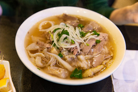 Traditional Beef Combination Pho Rice Noodle with Beef Innards, Onion, and Coriander in a Restaurant