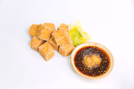 Mouthwatering Asian Fried Tofu Bean Curd Served with Garlic Soy Sauce on an Isolated White Backgroundの写真素材