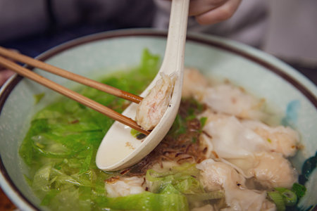 Delicious Asian Wonton Noodle Soup with Crispy Shallots in a Restaurant, Served with Wonton Scoop on...