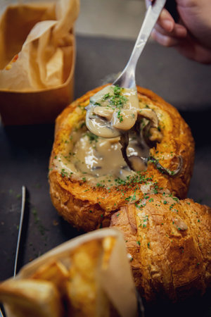 Gourmet Creamy Mushroom Soup Served in a Bread Bowl with Crisp Parsley Garnishの写真素材