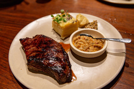 Succulent Seared Steak with a Golden Crust, Paired with Creamy Potato Mash and Savory Sauceの写真素材