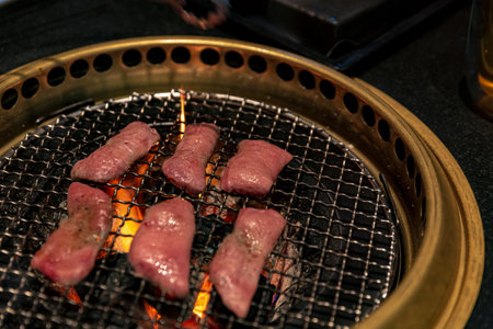 Ox Tongue Sizzling on Charcoal Grill Over Hot Coals for Japanese BBQ, Searing Juicy Cuts Enhanced by Grilling Techniquesの写真素材