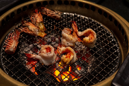 Skillfully grilled prawns, highlighted by the ambient lighting of a yakiniku restaurant, offering a glimpse into Japanese culinary traditionsの写真素材
