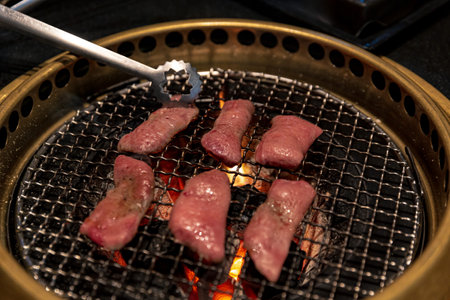 Grilled Ox Tongue on Charcoal Grill for Japanese or Korean BBQ, Juicy Cuts with Griddle Marks on Hot Coals, Creating an Authentic Dining Experienceの写真素材