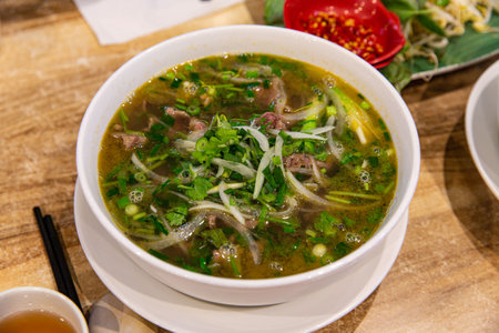 Classic Pho Bo: Vietnamese Beef Noodle Soup Served with Fresh Basil and Lime in an Aromatic Brothの写真素材