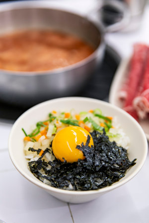 Bibim Rice Bowl: Traditional Korean Mixed Rice with Raw Egg Yolk, Seaweed, and Fresh Vegetablesの写真素材