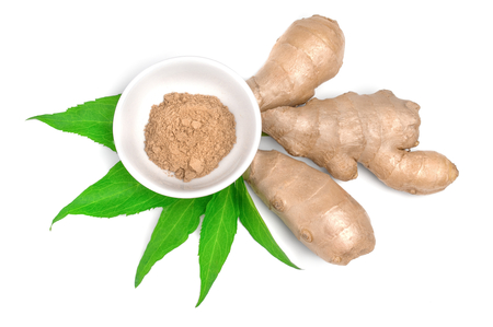ground ginger in bowl and root on a white.の写真素材
