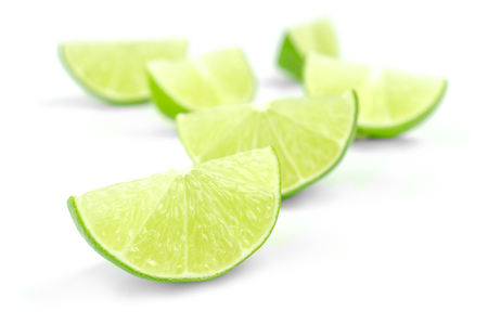 scattering of fresh lime wedges isolated on a white background.の写真素材