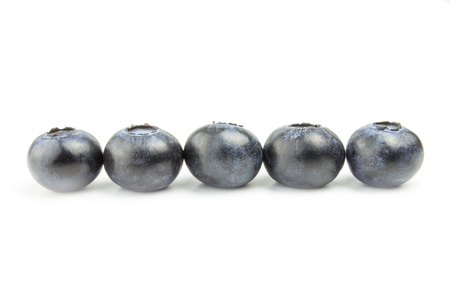 five fresh blueberries in line isolated on white background.の写真素材