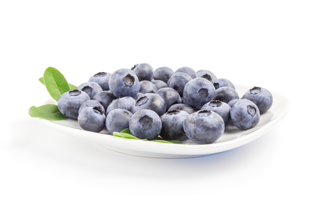 Close-up of fresh blueberries in white bowl on white background.の写真素材