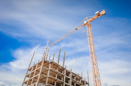 Multistorey building and construction works/High-rise houses and column craneの写真素材