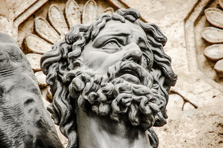Stone sculpture showing head of man with curly hair.の写真素材