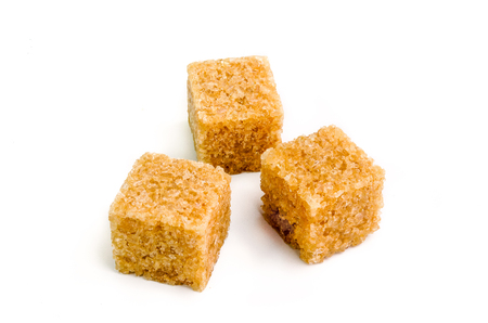 Three cubes of brown sugar with shadow on white background.の写真素材