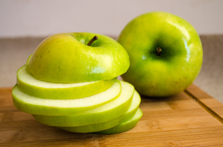 Apple circles on a wooden chopping board.の写真素材