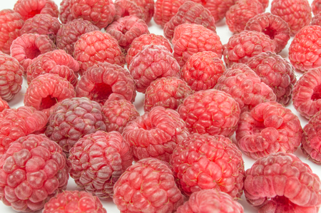 Fresh raspberries scattered isolated on white background cutout.