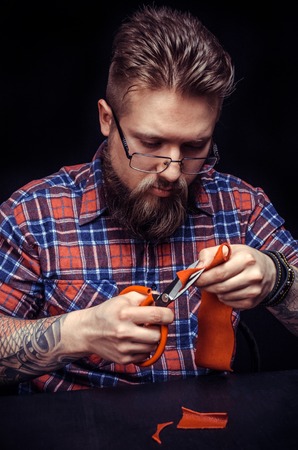 Male shoemaker cutting leather.の写真素材