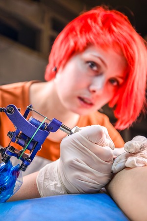 Master tattooist working tattooing in tatoo salonの写真素材