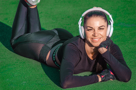 Sporty girl and headphones listen music and smile