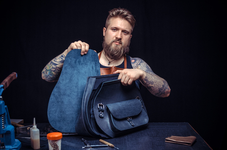 Leather handbag craftsman at work in a workshop