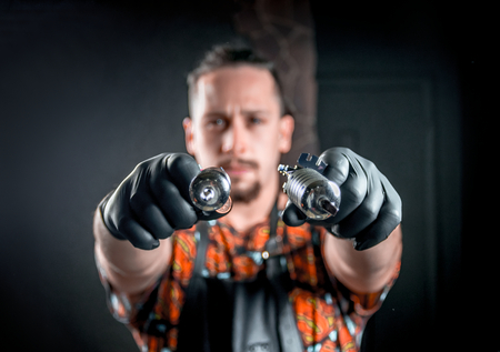 Professional tattoo artist with a tattoo machine in salonの写真素材