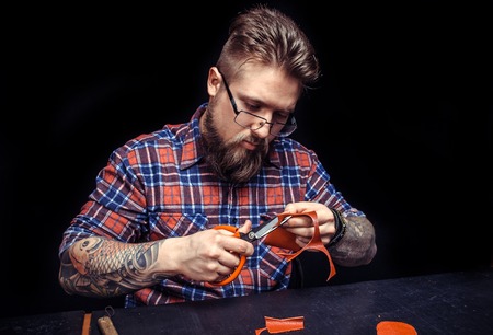Man working with leather produces a good product at the tanning shopの写真素材