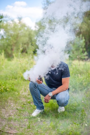 Stylish smoker blows up a couple an e-cigarette. Vaping.の写真素材