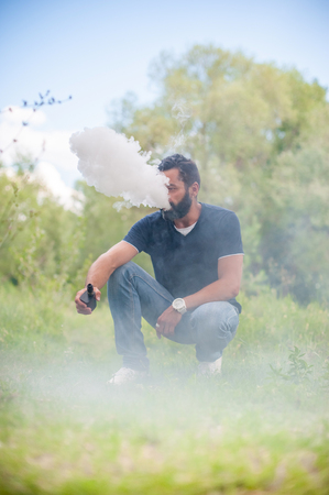 Stylish man exhales cloud of smoke. Handsome man.の写真素材