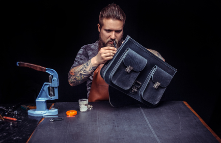 Currier working on a new leather product in his place of work