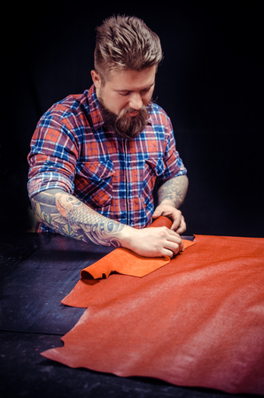 Man working with leather manufactures new product made of leather