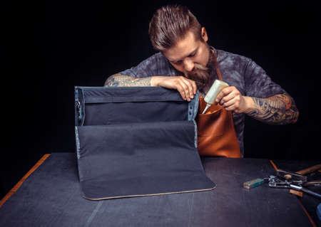 Artisan of leather manufacturing new leather product at the place of work