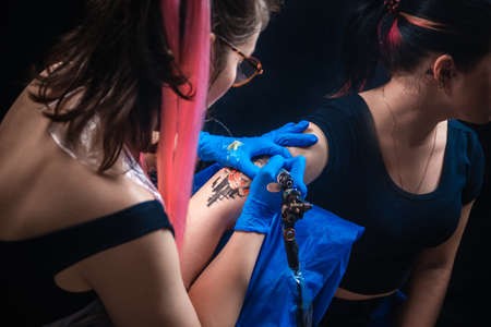 Tattooist showing process of making a tattooの写真素材