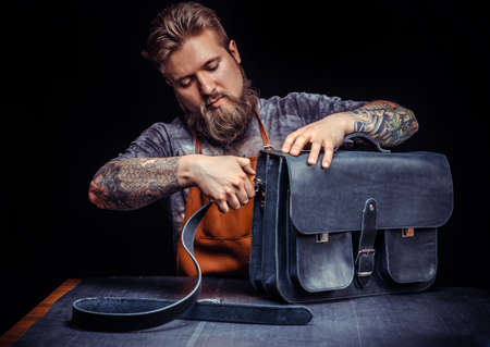 Professional Leather Worker works with leather at studio