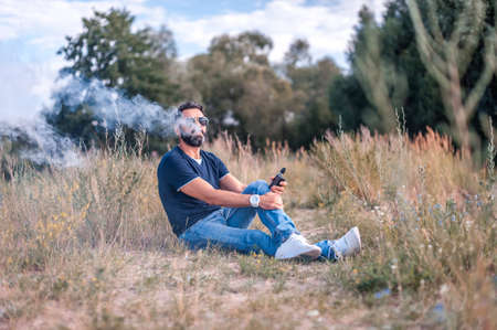 Confident smoker vaping an e-cigarette. Vaping concept.の写真素材